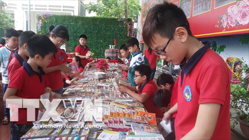 Các em học sinh đọc sách tại Ngày hội. Ảnh: Hương Thu - TTXVN
