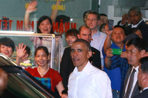 Người dân Hà Nội vẫy tay chào Tổng thống Hoa Kỳ Barack Obama khi ông rời quán ăn với tỉnh cảm nồng ấm . Ảnh: Doãn Tấn- TTXVN