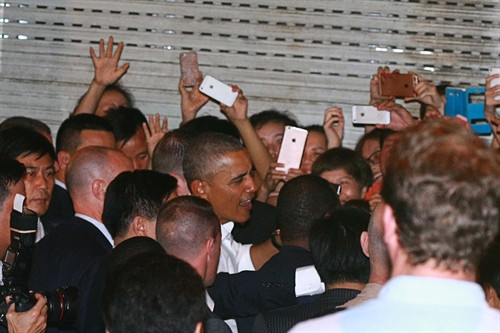 Rất đông người dân đã tới quán ăn để được nhìn thấy, được "chạm vào tay" ông và dùng điện thoại ghi lại khoảnh khắc của vị Tổng thống Hoa kỳ giữa lòng Thủ đô Hà Nội. Ảnh: Doãn Tấn- TTXVN