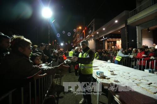 Chiếc bánh Vassilopita khổng lồ được cắt nhỏ và chia cho người dân ở Athens, Hy Lạp ngày 30/12. Ảnh THX/TTXVN Chiếc bánh Vassilopita khổng lồ được cắt nhỏ và chia cho người dân ở Athens, Hy Lạp ngày 30/12. Ảnh THX/TTXVN