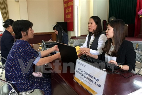 Thay vì đợi cả buổi như mọi khi, người dân phường Mỹ Đình 2 chỉ mất khoảng 30 phút chờ đợi để lấy lương. (Ảnh: T.H/Vietnam+)