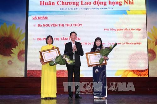 Phó Chủ tịch UBND TP. Hồ Chí Minh Trần Vĩnh Tuyến trao tặng Huân chương Lao động hạng Nhì cho 2 cá nhân tiêu biểu đạt thành tích xuất sắc. Ảnh: Thanh Vũ-TTXVN