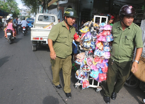 Lực lượng chức năng di dời những giá treo hàng hóa lấn chiếm vỉa hè tại phường 3, thành phố Bạc Liêu. Ảnh: Huỳnh Sử- TTXVN Lực lượng chức năng di dời những giá treo hàng hóa lấn chiếm vỉa hè tại phường 3, thành phố Bạc Liêu. Ảnh: Huỳnh Sử- TTXVN