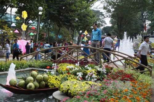 Người dân háo hức đến tham quan và chụp ảnh tại Hội Hoa xuân Đinh Dậu. Ảnh: Phương Vy – TTXVN