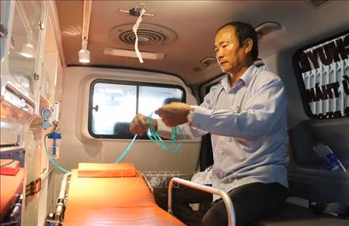 Ông Ngô Văn Đậu đang kiểm tra lại các thiết bị hỗ trợ cấp cứu trên xe chuyển viện do ông và gia đình mua trị giá 700 triệu đồng để vận chuyển bệnh nhân miễn phí. Ảnh: Công Mạo-TTXVN