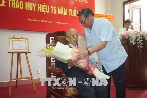 Đồng chí Lê Hồng Anh, nguyên Uỷ viên Bộ Chính trị, nguyên Thường trực Ban Bí thư tặng hoa chúc mừng đồng chí Trần Quốc Hương nhận Huy hiệu 75 tuổi Đảng. Ảnh: Anh Tuấn - TTXVN Đồng chí Lê Hồng Anh, nguyên Uỷ viên Bộ Chính trị, nguyên Thường trực Ban Bí thư tặng hoa chúc mừng đồng chí Trần Quốc Hương nhận Huy hiệu 75 tuổi Đảng. Ảnh: Anh Tuấn - TTXVN