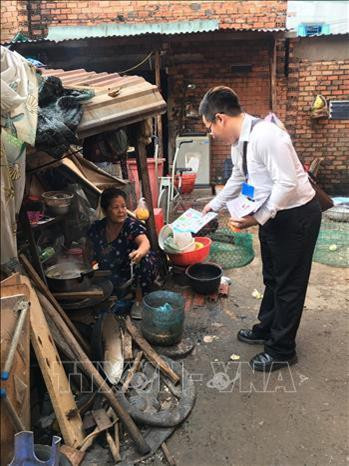Cán bộ phòng chống dịch Quận 6, Thành phố Hồ Chí Minh phát tờ rơi, tư vấn cách phòng tránh bệnh sốt xuất huyết cho người dân. Ảnh: Đinh Hằng – TTXVN