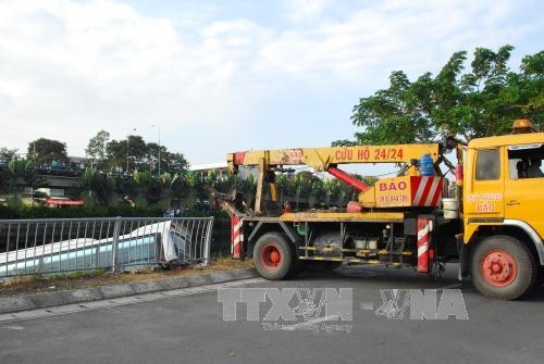 Xe cứu hộ được điều động đến hiện trường để cẩu chiếc xe khách lên trên đường. Ảnh: Mạnh Linh-TTXVN