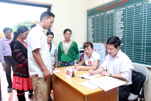 Cán bộ tổ bầu cử số 3, bản Mường Toong 3, xã Mường Toong, huyện Mường Nhé kiểm tra danh sách cử tri. Ảnh: Tuấn Anh – TTXVN