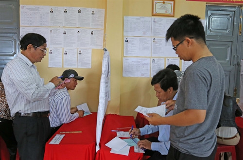 Cử tri Lâm Đồng tìm hiểu tiểu sử các ứng cử viên trước khi bỏ phiếu. Ảnh: Đặng Tuấn – TTXVN