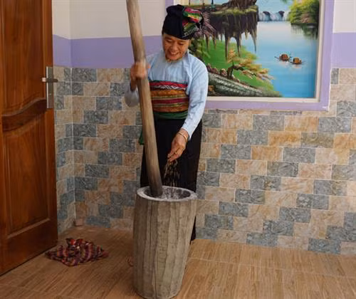 Bà Ngân Thị Nam đang giã gạo để chuẩn bị cho lễ cúng cơm mới.