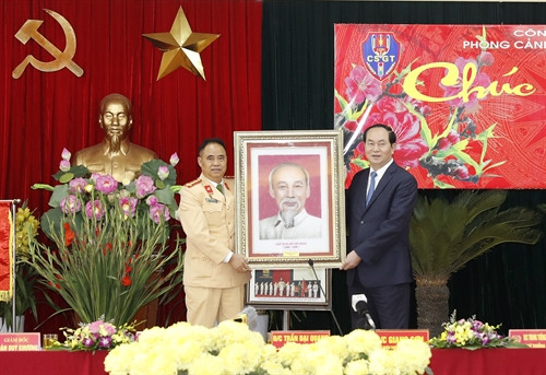 Chủ tịch nước Trần Đại Quang tặng bức tranh chân dung Chủ tịch Hồ Chí Minh cho Phòng Cảnh sát giao thông Đường bộ-Đường sắt. Nhan Sáng-TTXVN