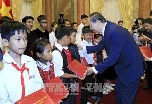 Chủ tịch nước Trần Đại Quang tặng quà cho các học sinh dân tộc thiểu số. Ảnh: Nhan Sáng – TTXVN