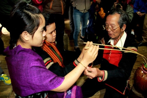 Thầy cúng trao vòng đồng cho hai người đại diện cho hai dân tộc kết nghĩa.