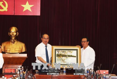 Bí thư Thành ủy Nguyễn Thiện Nhân thay mặt Thành ủy Thành phố (trái) nhận quà lưu niệm của Ban Đối ngoại Trung ương từ đồng chí Hoàng Bình Quân. Ảnh: Xuân Khu-TTXVN Bí thư Thành ủy Nguyễn Thiện Nhân thay mặt Thành ủy Thành phố (trái) nhận quà lưu niệm của Ban Đối ngoại Trung ương từ đồng chí Hoàng Bình Quân. Ảnh: Xuân Khu-TTXVN