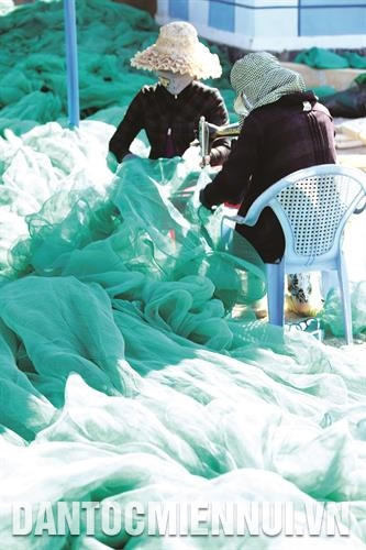 Nhiều phụ nữ ở xã Cam Bình làm nghề may lưới để có thêm thu nhập