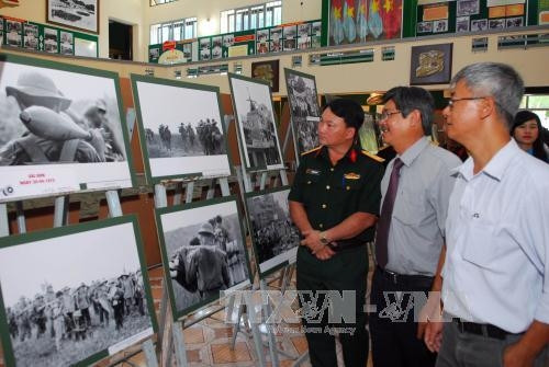 Nghệ sĩ nghiếp ảnh Minh Lộc (người cầm máy ảnh) và các đại biểu tham dự lễ khai mạc triển lãm