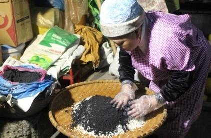 Gạo nếp vo sạch, để ráo, trộn cùng bột than cây mảy piạcy đến khi gạo quyện với bột than thành màu đen nhánh.