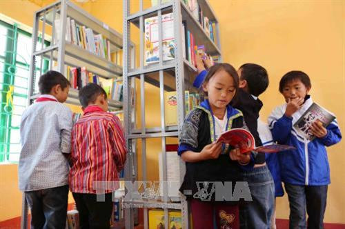 Học sinh trường Phổ thông Dân tộc bán trú Tiểu học và THCS Chế Tạo (xã Chế Tạo, huyện Mù Cang Chải) háo hức trước những cuốn sách mới. Ảnh: Thành Đạt – TTXVN