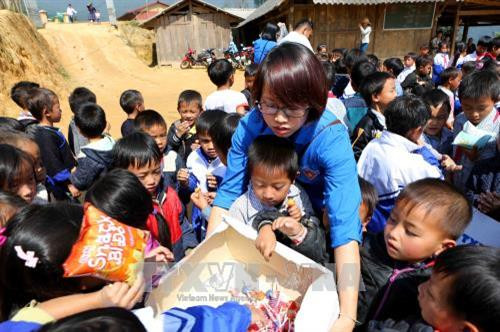 Đoàn viên thanh niên TTXVN phát quà cho các em nhỏ tại trường Phổ thông Dân tộc bán trú Tiểu học và THCS Chế Tạo (xã Chế Tạo, huyện Mù Cang Chải). Ảnh: Thành Đạt – TTXVN