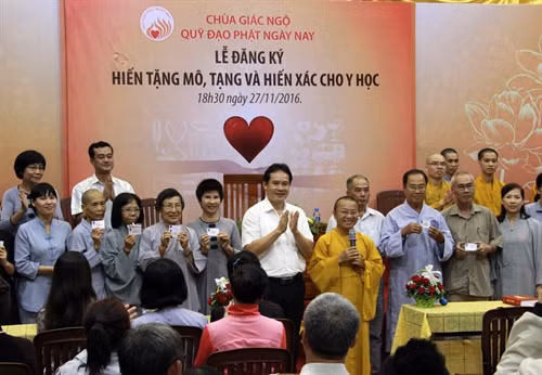 Đại diện Trung tâm Điều phối Quốc gia về ghép bộ phận cơ thể người trao thẻ đăng ký hiến mô, tạng cho các phật tử. Ảnh: Phương Vy- TTXVN