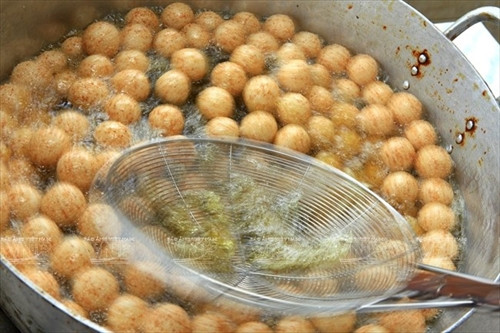 Khi rán bánh, người ta phải dùng một chiếc vợt đảo đều tay để bánh chín và tròn đều. Khi rán bánh, người ta phải dùng một chiếc vợt đảo đều tay để bánh chín và tròn đều.