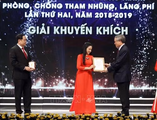Đồng chí Trần Thanh Mẫn, Bí thư Trung ương Đảng, Ủy ban Trung ương Mặt trận Tổ quốc Việt Nam và đồng chí Nguyễn Hòa Bình, Bí thư Trung ương Đảng, Chánh án Tòa án nhân dân tối cao trao giải khuyến khích cho tác giả Vũ Quỳnh Hoa, Ban Biên tập tin trong nước, Thông tấn xã Việt Nam. Ảnh: Thống Nhất – TTXVN