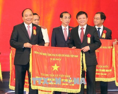 Thủ tướng Nguyễn Xuân Phúc tặng cờ thi đua của Chính phủ cho Thông tấn xã Việt Nam, đơn vị dẫn đầu phong trào thi đua yêu nước năm 2017. Ảnh: Doãn Tấn - TTXVN.