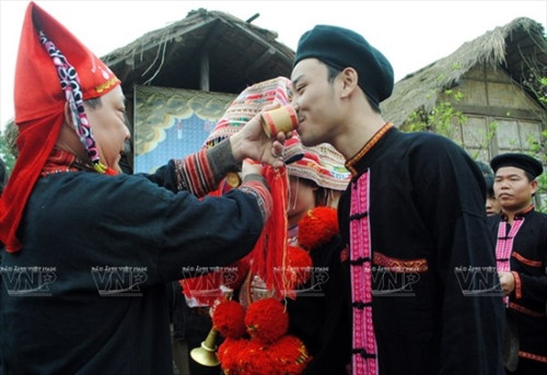 Cô dâu chú rể uống chén rượu mà thầy cúng vừa dùng để làm lễ trước khi bước vào nhà.