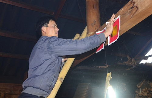 Người Mông dán giấy đỏ trong nhà dịp Tết để cầu mong những điềm may sẽ đến trong năm mới.