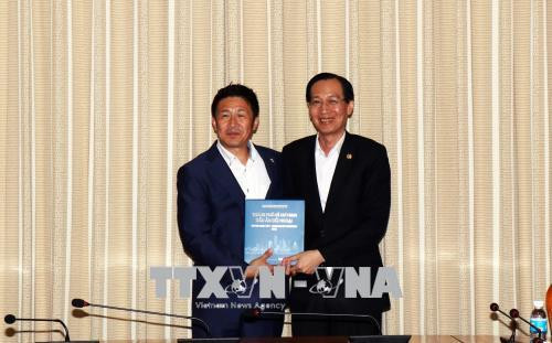 Ông Lê Thanh Liêm tặng sách giới thiệu Thành phố Hồ Chí Minh cho ông Uchida Shigenobu. Ảnh: Xuân Khu-TTXVN