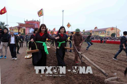 Các thôn nữ đi sau gieo hạt giống để cầu mong một năm mới với mùa màng tươi tốt bội thu. Ảnh: Quý Trung – TTXVN