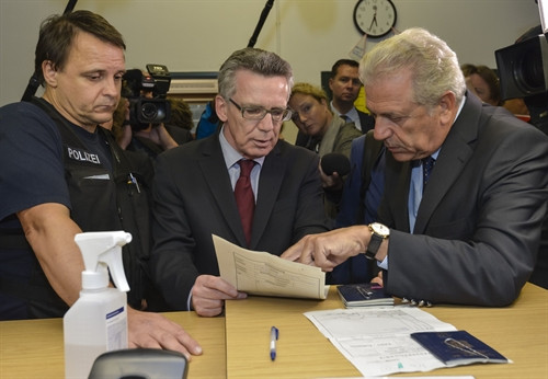 Trong ảnh: Cao ủy châu Âu phụ trách nhập cư, các vấn đề đối nội và quyền công dân Dimitris Avramopoulos (phải) và Bộ trưởng Nội vụ Đức Thomas de Maiziere (giữa) xem xét hồ sơ tị nạn tại sở cảnh sát liên bang ở Rosenheim, miền nam nước Đức ngày 17/9. AFP-TTXVN