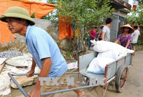 Người dân thôn Nhân Lý, xã Nam Phương Tiến đến nhận hàng cứu trợ tại các tổ trong thôn (ảnh chụp chiều ngày 7/8/2018). Ảnh: Thành Đạt