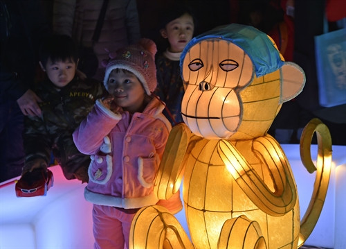 Các em nhỏ chụp ảnh với một mẫu đèn lồng hình chú khỉ tại một công viên ở Đài Bắc, Đài Loan, Trung Quốc ngày 21/2. AFP/TTXVN