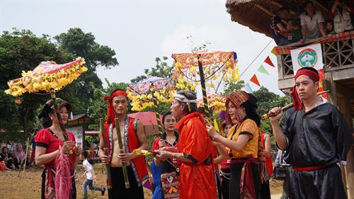 Thầy mo ban lộc từ cây nêu cho con nuôi. Ảnh: Nam Sương