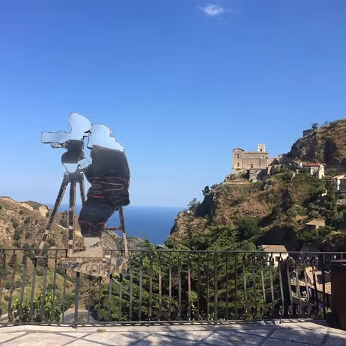 Trong phim "Bố già" của nhà văn Mario Puzo, thị trấn Modica ở vùng Sicily là quê hương của nhân vật ông trùm mafia Vito Corleone. Ảnh: Pinimg. Du khách đến thị trấn thường ăn bánh quy ngọt và uống Granitas tại quán bar Vitelli, nơi nhân vật Michael Corleone từng ngồi, khi về quê cha để lẩn trốn sự truy đuổi. Ảnh: James Dunn/Daily Mail. Quán bar trong phim và ngoài đời thực không có sự khác biệt, bên ngoài được phủ xanh bằng giàn cây leo. Ảnh: Shutterstock/Goran Vrhovac. Một cảnh trong phim "Bố già". Trong phim, Michael Corleone cùng các bạn của mình đến quán bar để xin cưới con gái chủ quán, người anh đã yêu ngay lần đầu gặp trên một con đường làng. Ảnh: Paramount Pictures/REX/Shutterstock. Từ bar Vitelli, du khách có thể nhìn thấy nhà thờ Savoca, nơi đạo diễn Francis Ford Coppola quay cảnh đám cưới của Michael Corleone và người vợ đầu tiên. Ảnh: Shutterstock/Anadman BVBA. Nhờ những cảnh quay trong bộ phim huyền thoại, Sicily trở thành thỏi nam châm thu hút du khách từ khắp nơi trên thế giới đổ về. Ảnh: James Dunn/Daily Mail. Nhiều du khách thích thú khi được thuê lái những chiếc xe hơi cổ đến núi Etna, ngọn núi lửa nổi tiếng của hòn đảo và ghé thăm những vườn nho trong vùng. Ảnh: James Dunn/Daily Mail. Người dân Sicily ưu ái dành tình cảm cho đạo diễn Francis Ford Coppola bằng một bức tượng kim loại hình ông bên máy quay phim. Phía xa là nhà thờ Santa Maria Degli Angeli, nơi quay cảnh ông trùm Michael Corleone kết hôn với người vợ đầu tiên. Ảnh: James Dunn/Daily Mail. Cảnh quan vùng Sicily giữ được nét trầm mặc, yên tĩnh và có phần bí hiểm, giống như những gì đã xuất hiện trên phim cách đây hơn 40 năm. Ảnh: Shutterstock/Nikiforov Alexander. Một địa điểm nổi tiếng khác ở Sicily là nơi nhân vật Vito Corleone sinh ra, xuất hiện trong "Bố già" phần III. Ảnh: James Dunn/Daily Mail. Ngoài khu nội thất sang trọng, bên ngoài biệt thự là khu vực ăn uống mở. Du khách có thể thưởng thức rượu vang và món ăn ngon của địa phương vào những buổi chiều nắng nóng. Ảnh: James Dunn/Daily Mail. Không gian mở hướng ra biển mang lại cảm giác thư giãn yên tĩnh. Ảnh: James Dunn/Daily Mail. Sau chuyến thăm các địa danh xuất hiện trong phim, du khách có thể ghé một nhà hát cổ tuyệt đẹp nằm trên quả đồi nhỏ nhìn ra vịnh. Ảnh: Shutterstock/Arts lllustrated Studios.