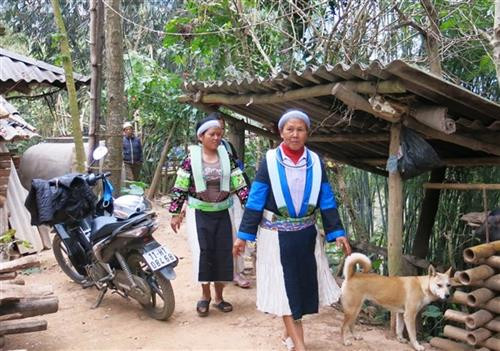 Phụ nữ Mông Trắng búi tóc sau gáy và quấn khăn rằn.