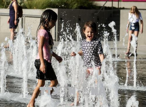 Trẻ em giải nhiệt tránh nóng tại một đài phun nước ở Los Angeles, Mỹ ngày 24/7. Ảnh: THX/TTXVN Trẻ em giải nhiệt tránh nóng tại một đài phun nước ở Los Angeles, Mỹ ngày 24/7. Ảnh: THX/TTXVN