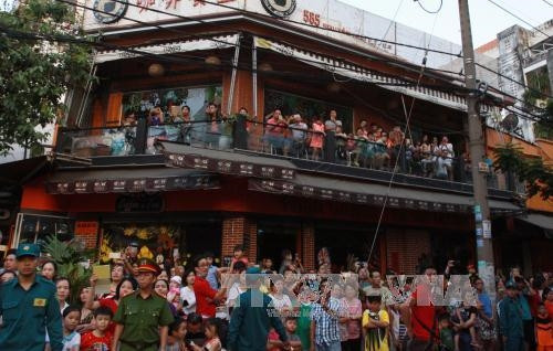 Đông đảo người dân hân hoan chào đón đoàn diễu hành qua các đường phố lớn của Quận 5. Ảnh: Phương Vy - TTXVN