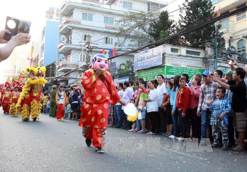Các diễn viên biểu diễn nghệ thuật diễu hành qua các đường phố lớn của Quận 5. Ảnh: Phương Vy - TTXVN