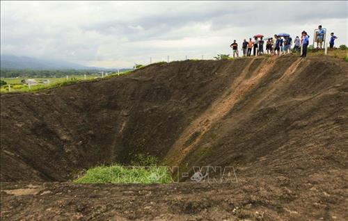 Du khách tham quan Hố Bộc phá trên Di tích Đồi A1. Ảnh: Xuân Tư – TTXVN