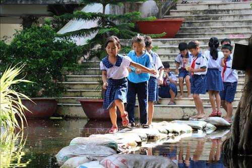 Sân trường Tiểu học Vĩnh Đại (Tân Hưng) ngập trong nước lũ, phụ huynh và giáo viên phải dùng bao cát đắp đường cho các em học sinh đi lại. Ảnh: Bùi Giang - TTXVN Sân trường Tiểu học Vĩnh Đại (Tân Hưng) ngập trong nước lũ, phụ huynh và giáo viên phải dùng bao cát đắp đường cho các em học sinh đi lại. Ảnh: Bùi Giang - TTXVN