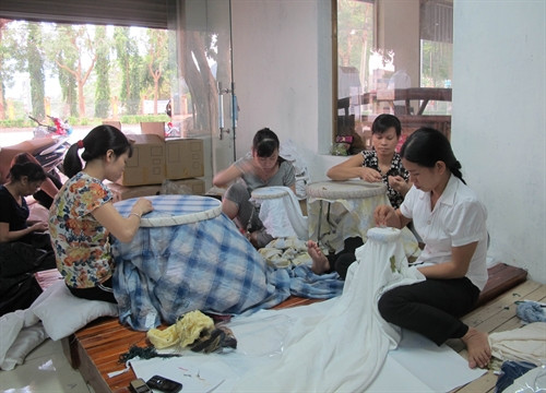 Thợ thêu hoàn thành sản phẩm tại cơ sở thêu Minh Trang, xã Ninh Hải, huyện Hoa Lư. Ảnh: Thùy Dung – TTXVN