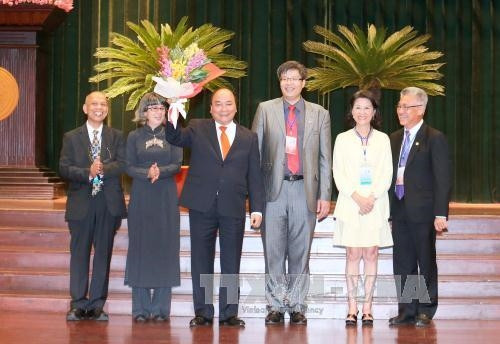 Đại diện kiều bào 5 châu tặng hoa Thủ tướng Nguyễn Xuân Phúc. Ảnh: Thống Nhất-TTXVN