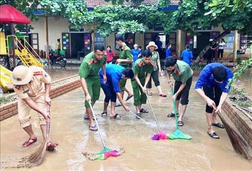 Các cán bộ chiến sĩ công an trên địa bàn tỉnh Quảng Bình hỗ trợ các trường học ở vùng lũ của huyện Minh Hóa, Tuyên Hóa, thị xã Ba Đồn…khắc phục hậu quả mưa lũ. Ảnh: TTXVN