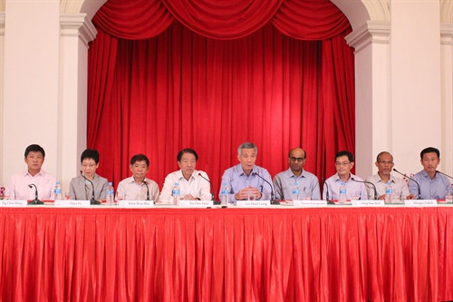 Thủ tướng Singapore Lý Hiển Long (ngồi giữa) công bố thành phần nội các mới trong Chính phủ gồm Phó Thủ tướng Tiêu Chí Hiền (bên trái), Phó Thủ tướng Tharman Shanmugaratnam (bên phải) cùng các Bộ trưởng. Ảnh: TTXVN tại Singaopre