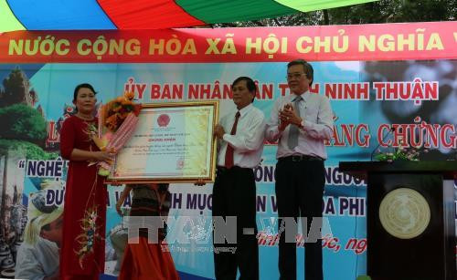 Phó Chủ tịch UBND tỉnh Ninh Thuận Lê Văn Bình trao Bằng chứng nhận "Nghệ thuật làm gốm truyền thống của người Chăm làng "Bàu Trúc" cho đại diện làng Chăm Bàu Trúc. Ảnh: Đức Ánh - TTXVN