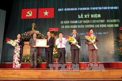 Chủ tịch UBND Thành phố Hồ Chí Minh Nguyễn Thành Phong thừa lệnh Chủ tịch nước trao Huân chương Lao động hạng Nhì cho Đảng bộ, Chính quyền và Nhân dân Quận 2. Ảnh: Thanh Vũ - TTXVN