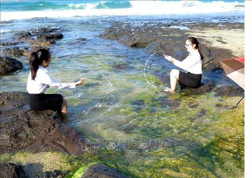 Du khách thích thú vui đùa cùng sóng biển bên bãi đá rêu xanh. Ảnh: Phước Ngọc-TTXVN Du khách thích thú vui đùa cùng sóng biển bên bãi đá rêu xanh. Ảnh: Phước Ngọc-TTXVN